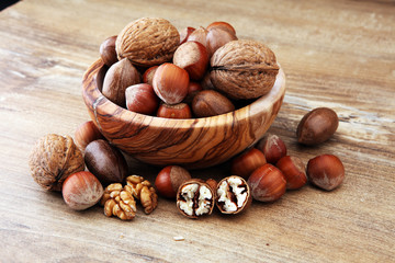Large diversity of healthy nuts in wooden bowl.
