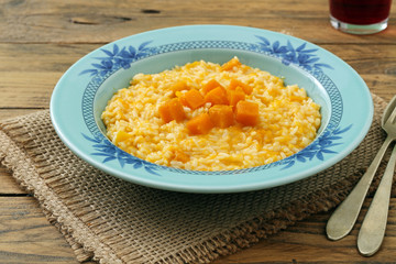 risotto italiano con zucca gialla  su sfondo rustico