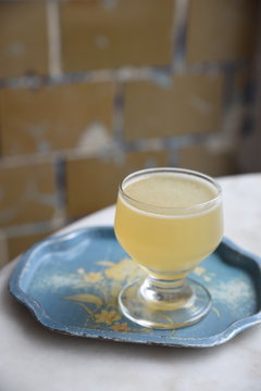 Glass of lemon and gin cocktail on rustic tray 