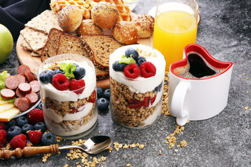Breakfast served with coffee, orange juice, bread, parfaits and fruits. Balanced diet