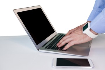 Cropped hand of businessman wearing smart watch while using