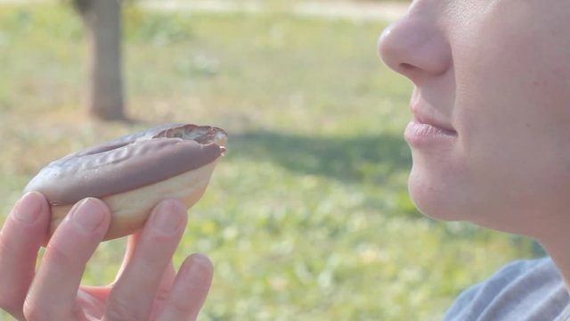 female(teenager)eats donut during the pick nick in the park
