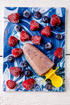 Photo on top of frozen blueberries and raspberries, fruit ice