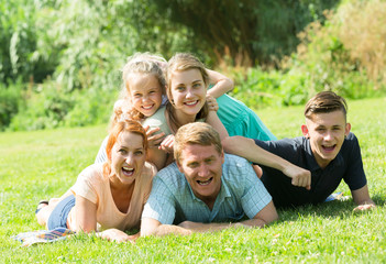 Naklejka na ściany i meble the large family lying on the grass in park.