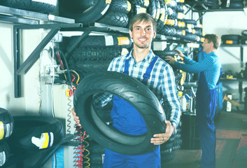 Obraz na płótnie Canvas worker holding new tyre