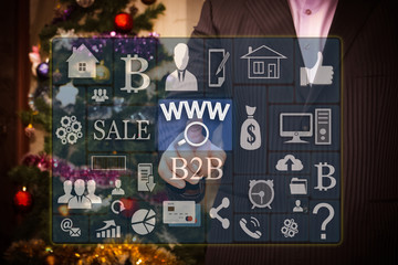 The businessman chooses www online searches on the touch screen, the backdrop of the Christmas tree and decorations. Special toning .