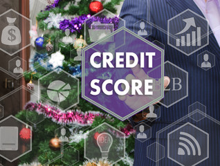 The businessman chooses CREDIT SCORE on the touch screen, the backdrop of the Christmas tree and decorations. Special toning .