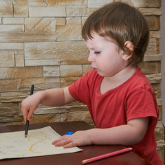 Mała dziewczynka rysuje kredką po dokumentach.