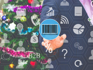 The businessman chooses  barcode on the touch screen, the backdrop of the Christmas tree and decorations. Special toning .