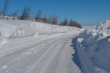 The road is cleared of snow and high drifts.