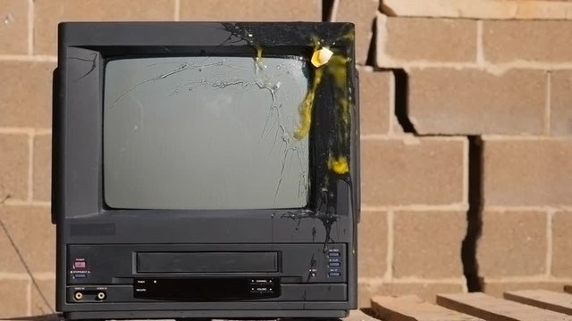 Eggs are broken about the TV screen. Slow motion video