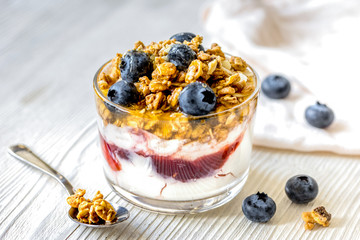 Morning granola with yogurt and berries on white kitchen backgro
