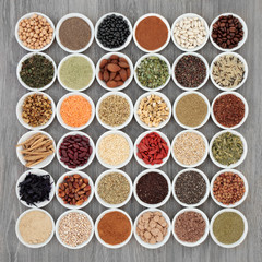 Dried diet super food with grains, cereals, legumes,  supplement powders, fruit, seeds, nuts and herbs used as appetite suppressants. Foods high in omega 3, antioxidants, fibre and vitamins. Top view.