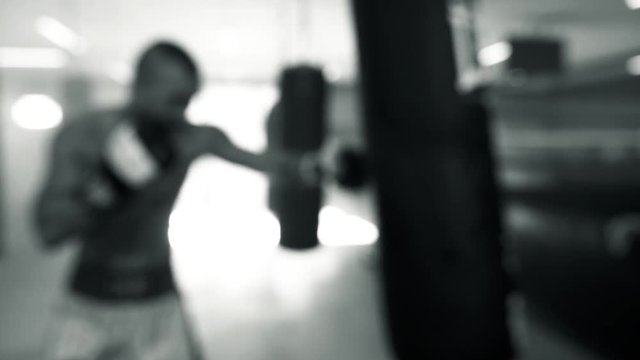 boxer punching bag in gym black and white out of focus