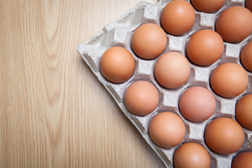 brown chicken eggs in the cardboard egg tray with copy space