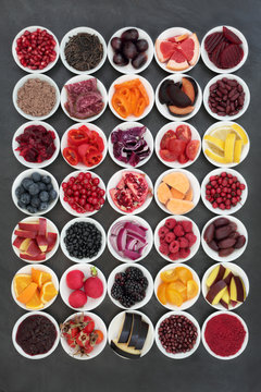 Large health food collection with fruit, vegetable, pulses and grains on slate background. Healthy foods very high in anthocyanins, antioxidants, vitamins and minerals. Healthy eating concept.
