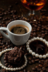 cup of coffee with a gift necklace and coffee beans in background and a red luxury box with jewelry	portrait mode