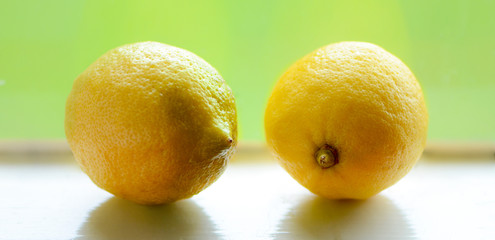 Two lemons on a window with a background view of a green field