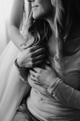 Bride on her wedding embrace smiling mom. Senior adult woman holding her daughter's hands near heart. Concept of relationship, love and care