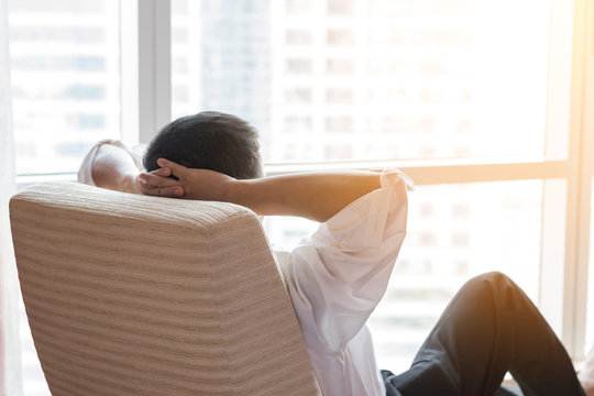 Life-work balance and city living life style concept of business man relaxing, take it easy in office room resting with thoughtful mind thinking of lifestyle quality looking forward to urban scene