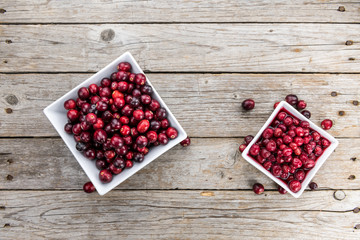 Portion of healthy Preserved Cranberries on an old wooden table (selective focus; close-up shot)