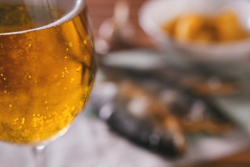 Beer and dry fish on wooden table - blurred background