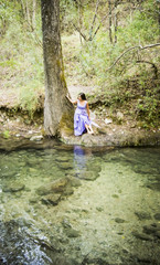 Fototapeta na wymiar Beautiful woman on the bank of a mountain river with an evening dress