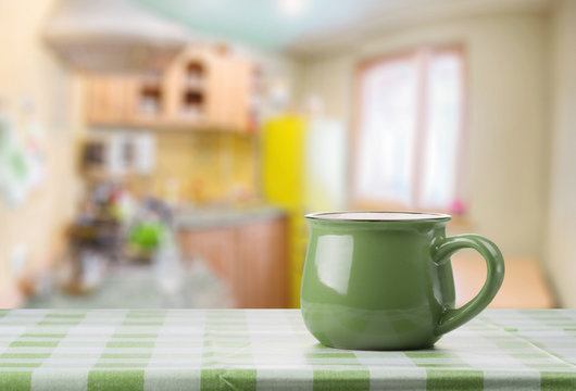 A green cup on the kitchen table