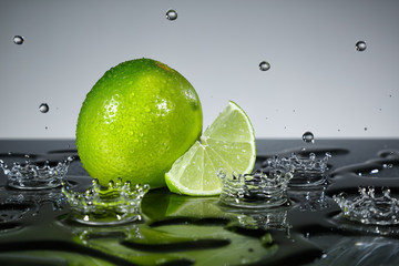 Obraz na płótnie Canvas Lime with raindrops on grey background
