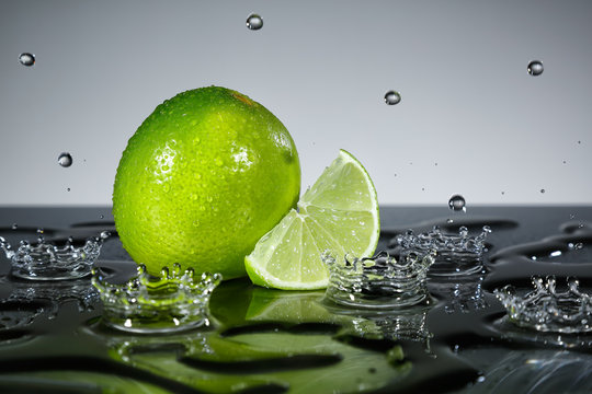 Fototapeta Lime with raindrops on grey background