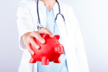 Arzt mit Spardose für Geld in der Hand