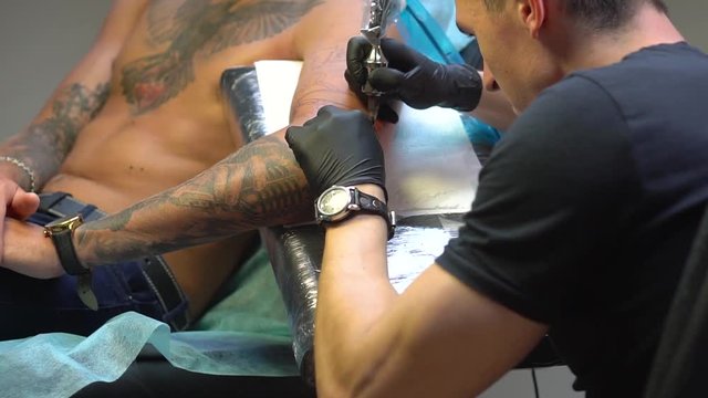 Design made by tattooing tool getting tattoos by man