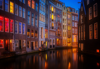 Fototapeta na wymiar Illuminated houses over canal with reflections at night, Amstardam, Netherlands, retro toned