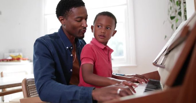 Father teaching Son to play the piano