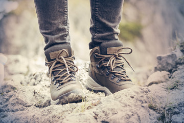 Girls hiking boots. Mountain landscape. Dirty earth and stones