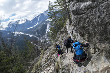 Fototapeta premium Tourists coming down from the steep slope in the mountains. Tatry, Poland