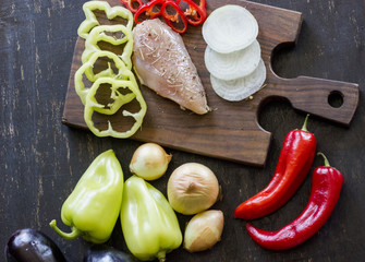 A composition of fresh vegetables laying on a dark wooden background