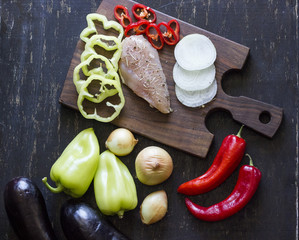 A composition of fresh vegetables laying on a dark wooden background