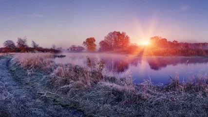 Türaufkleber Natur Sonnenaufgang auf der frostigen Natur des Herbstes. Landschaft der hellen Morgendämmerung über dem Fluss. Gras mit Raureif scheint auf Sonnenlicht