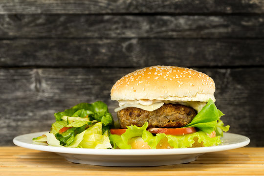 Delicous grilled beef burger on rustic background