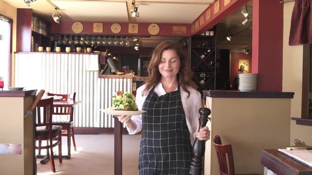 Medium shot of a waitress with a plate of food