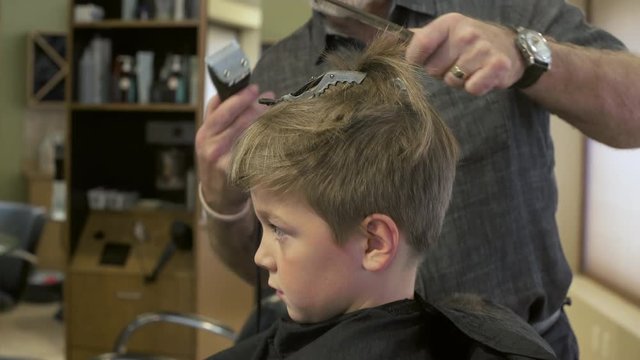 Boy having his hair cut in a barbershop
