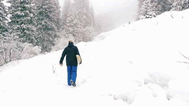 4k footage of snowboarder man adventure to winter mountain