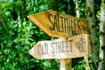 Wooden street sign pointing to Saltmills and Old Street