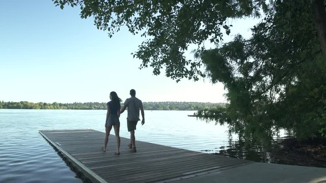 A young couple walking on a pier