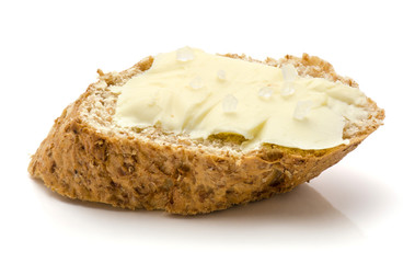 One wheat bran bread snack with butter and salt isolated on white background