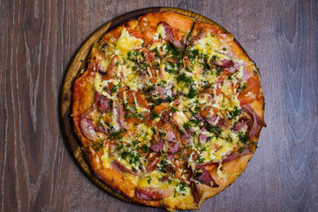 pizza with ham and cheese on a board