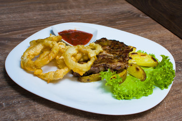 steak with onion rings and sauce