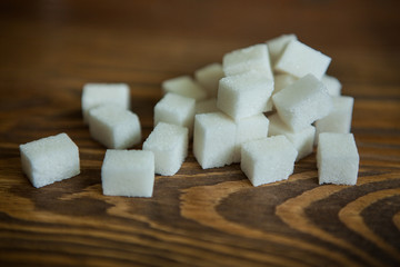 White sugar on brown wooden background