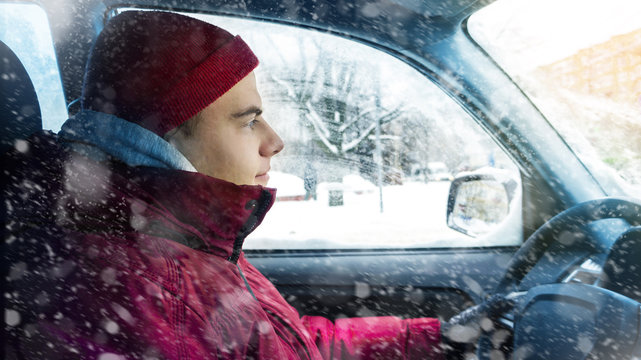 A Man In Winter Clothes Drives A Car In Winter